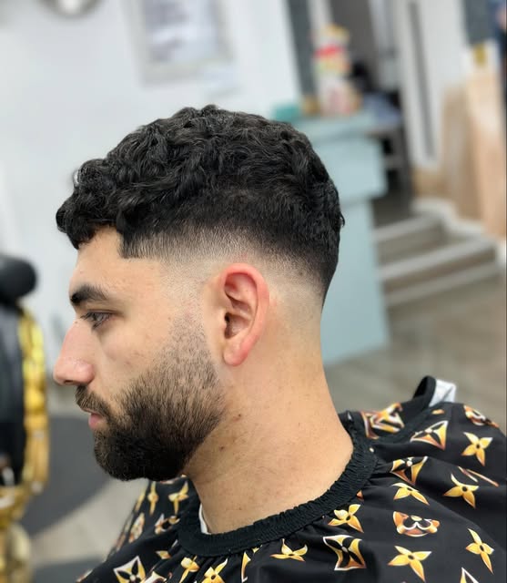 Textured curls, a precise fade and a shaped beard at The Room Barber